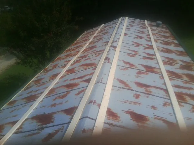 Rusted metal roof panels with new wood purlins before replacement — Storm Damage Roof Repair in Newark Valley by Roofing Brothers